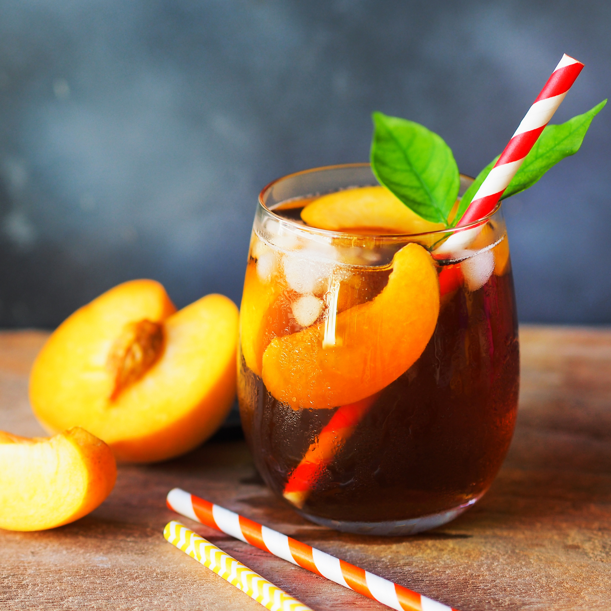 Peach iced tea in a glass with straw